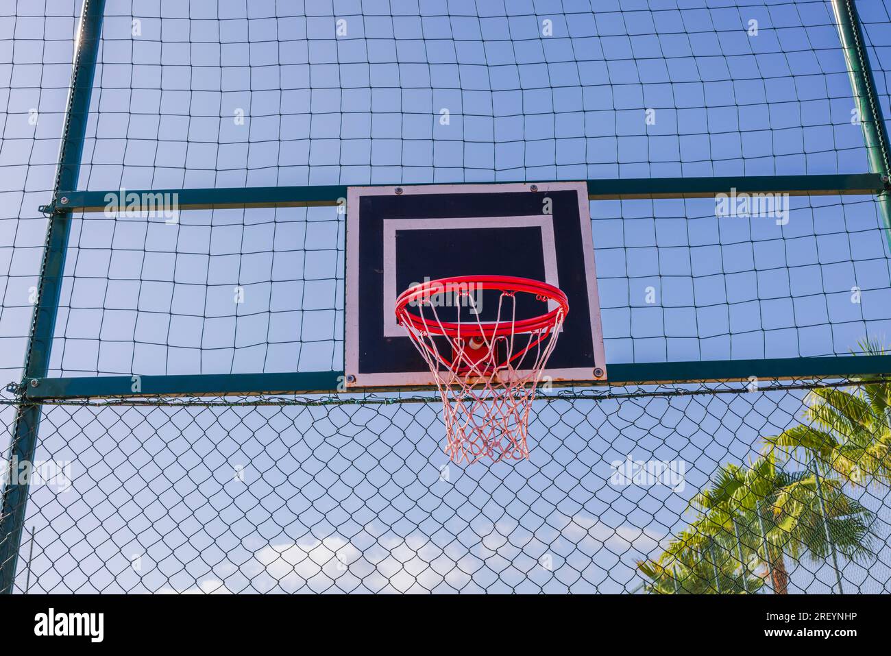 Closeup view of basketball hoop on sports field on blue sky background