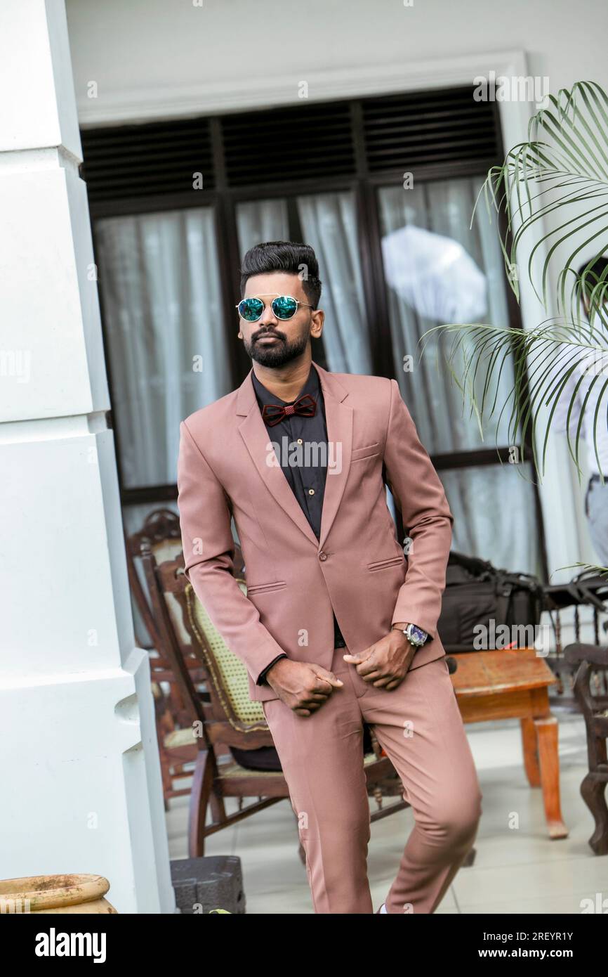 Handsome young indian man in beige suit and sunglasses Stock Photo