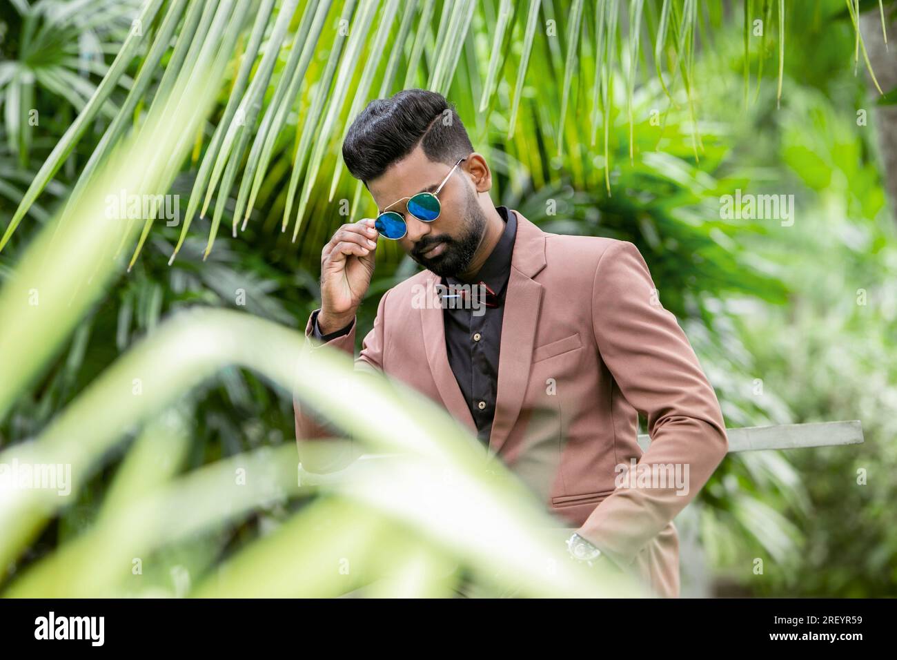 Handsome young indian man in suit and sunglasses posing outdoor Stock Photo