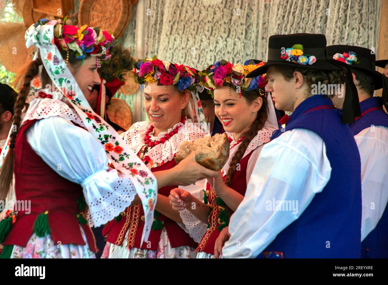 Costumed dancers share a slice of ceremonial bread in a historical
