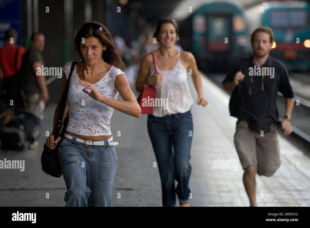 Three people running along a platform in an Italian train station Stock ...