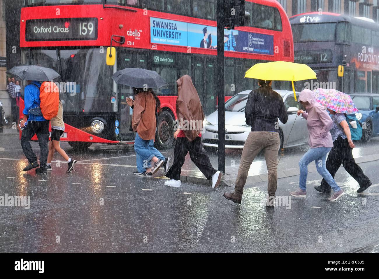 London, UK. 30th July, 2023. A heavy rain shower in Westminster causes