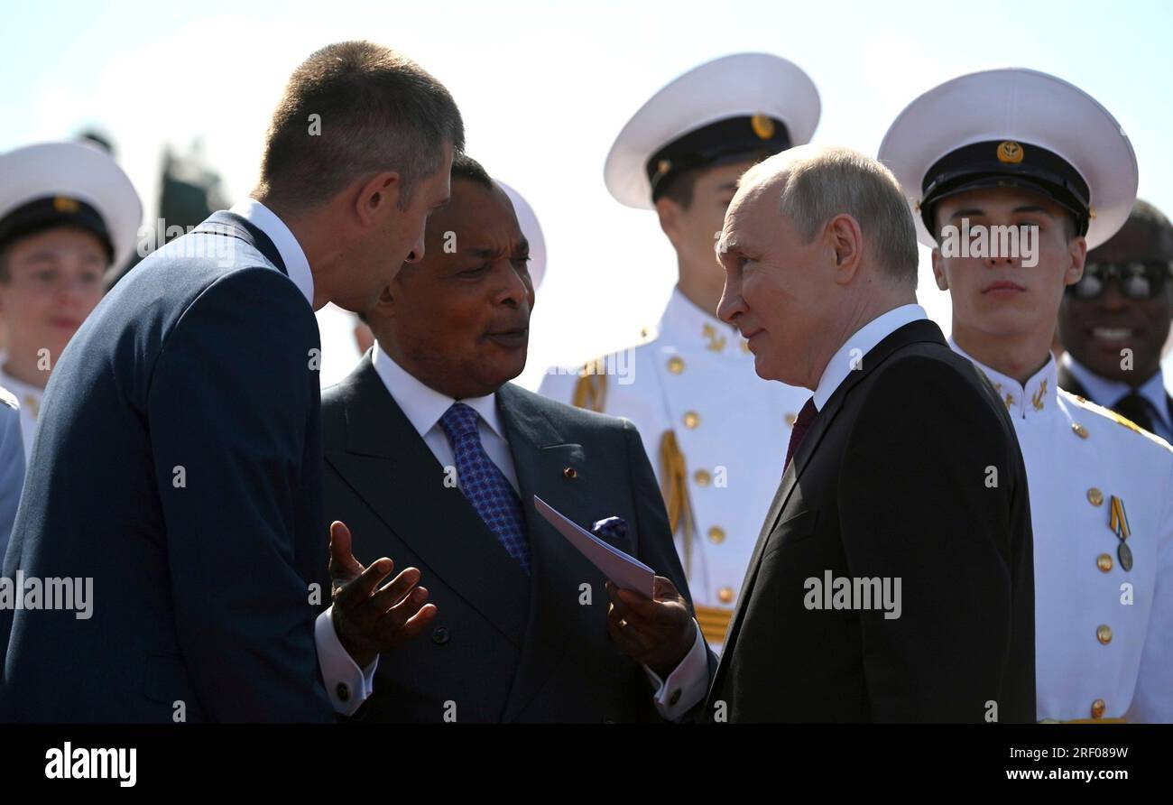 St Petersburg, Russia. 30th July, 2023. Russian President Vladimir Putin, right, speaks to Congo President Denis Sassou Nguesso, left, through the interrupter during Navy Day celebrations, July 30, 2023 in St. Petersburg, Russia. Credit: Alexander Kazakov/Kremlin Pool/Alamy Live News Stock Photo