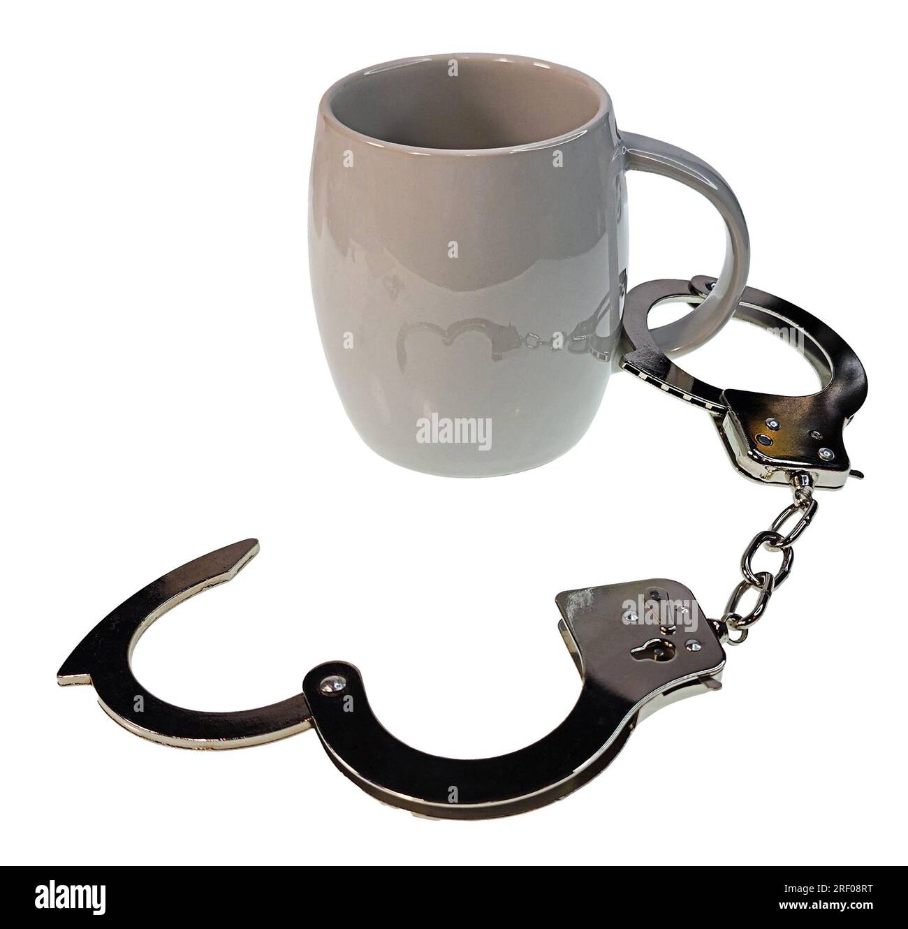 A pair of silver handcuffs attached to coffee cup showing addiction to ...