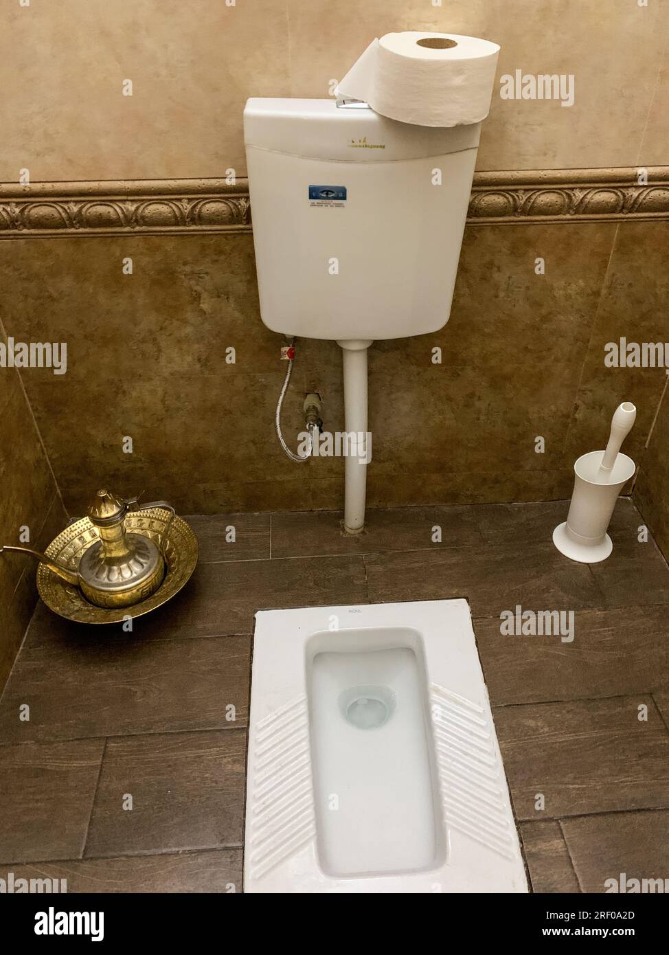 Kazakhstan, Almaty. Turkish or Squat Toliet.  Note Ewer of Water for those who prefer to wash rather than wipe with toilet paper. Stock Photo