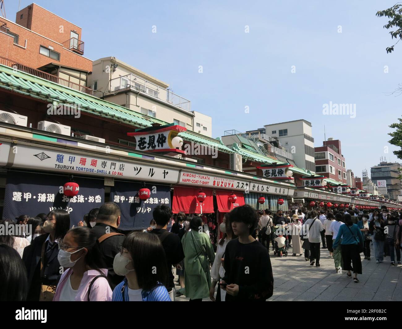 Crowds of tourists & visitors throng the streets surrounding the Senso-ji Temple which are filled with stalls & booths selling souvenirs & sweets. Stock Photo