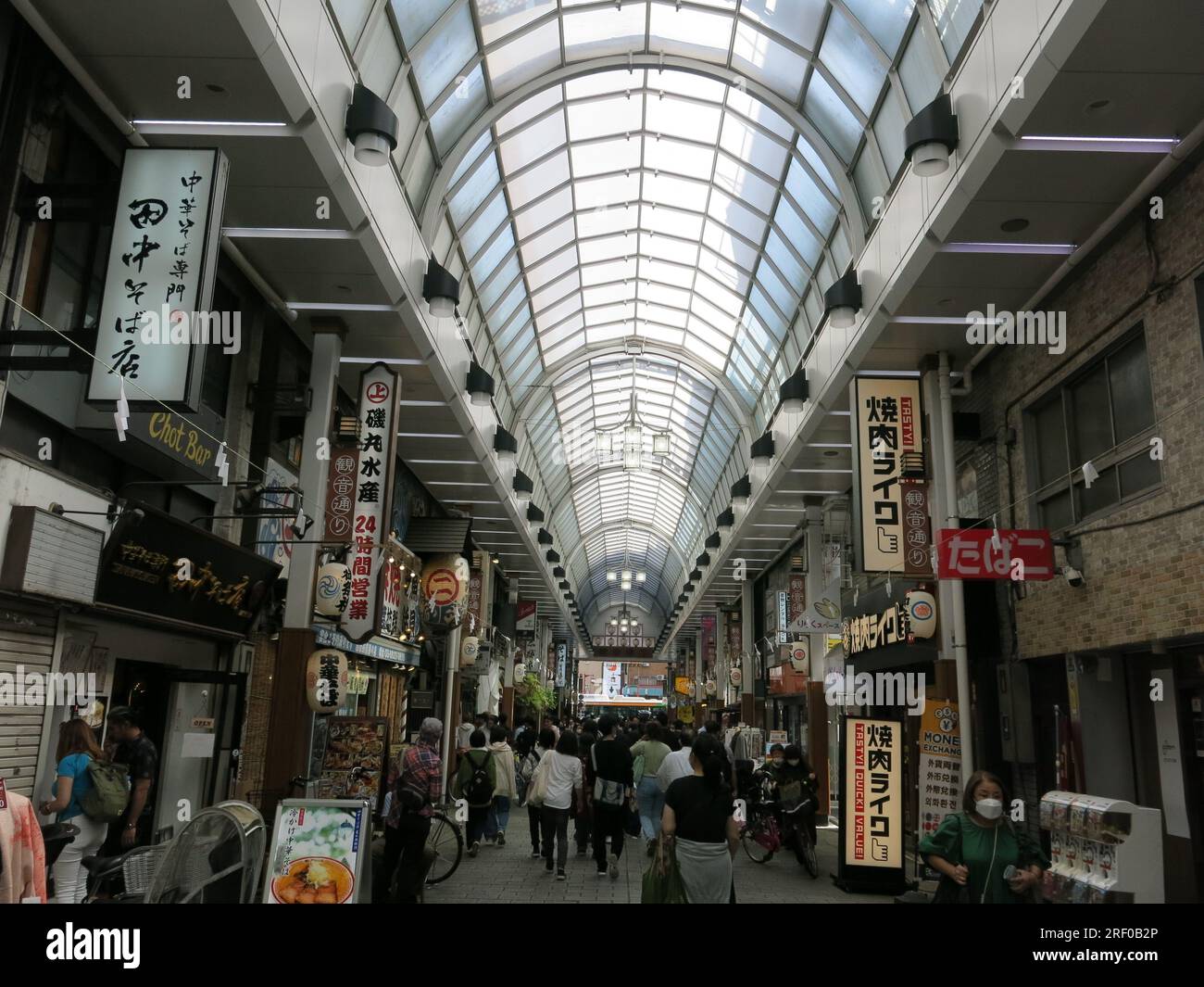 The covered arcade of Shin Nakamise shopping street in the busy tourist area of Asakusa is filled with shops & restaurants. Stock Photo