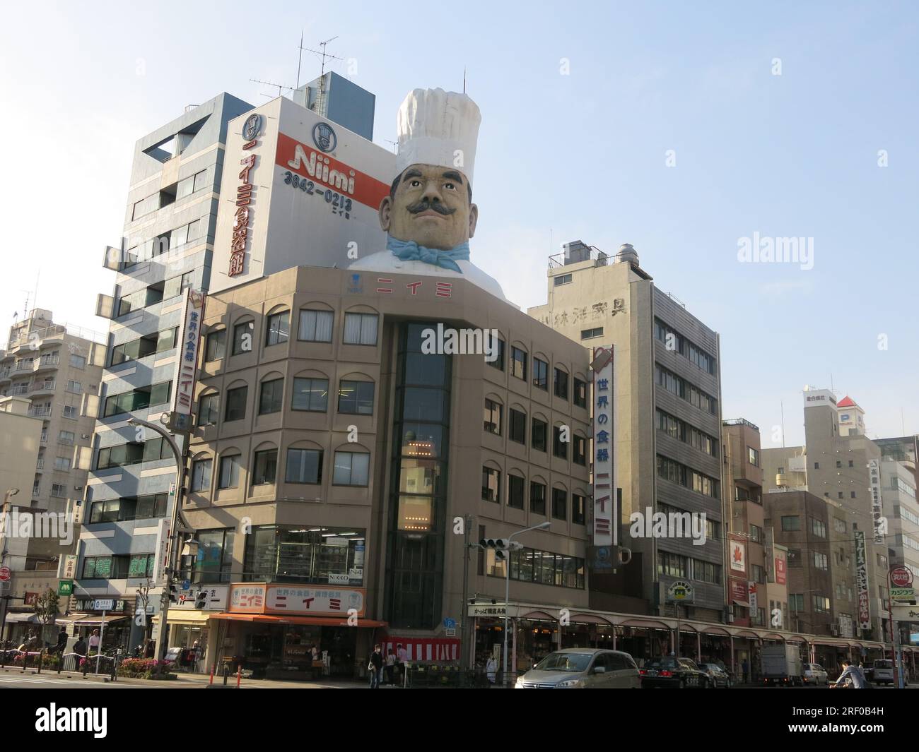 An off-beat tourist destination, view of the southern end of Kappabashi-dori with a model chef & giant teacups signifying 'Kitchen Street'. Stock Photo