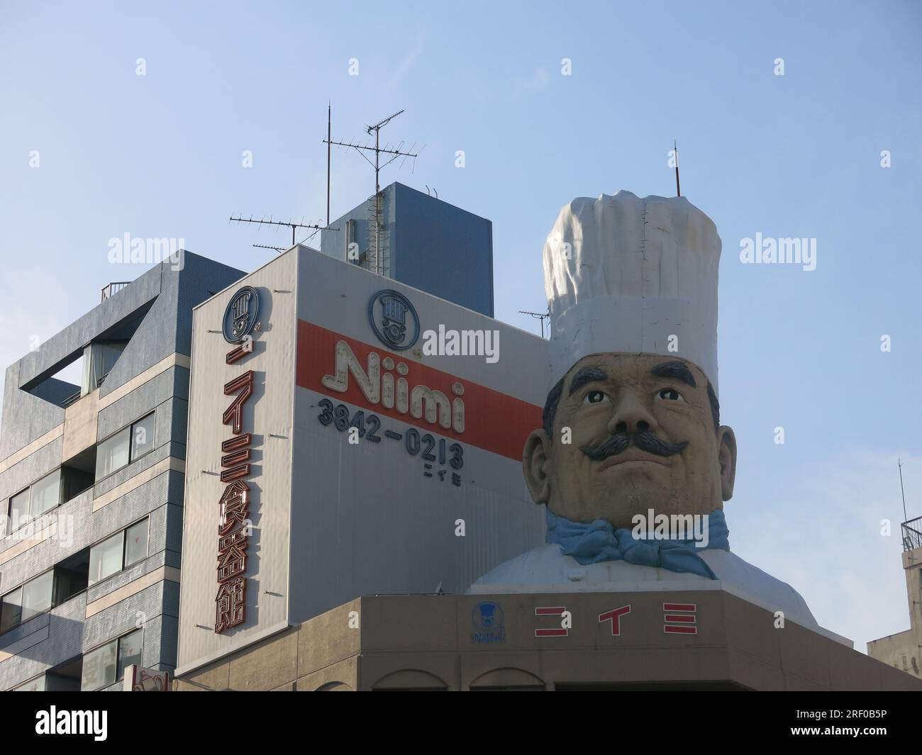 Giant model of a chef in a chef's hat on the top of a building on Kappabashi Street at the southern end of 'Kitchen Street', a Tokyo retail district. Stock Photo