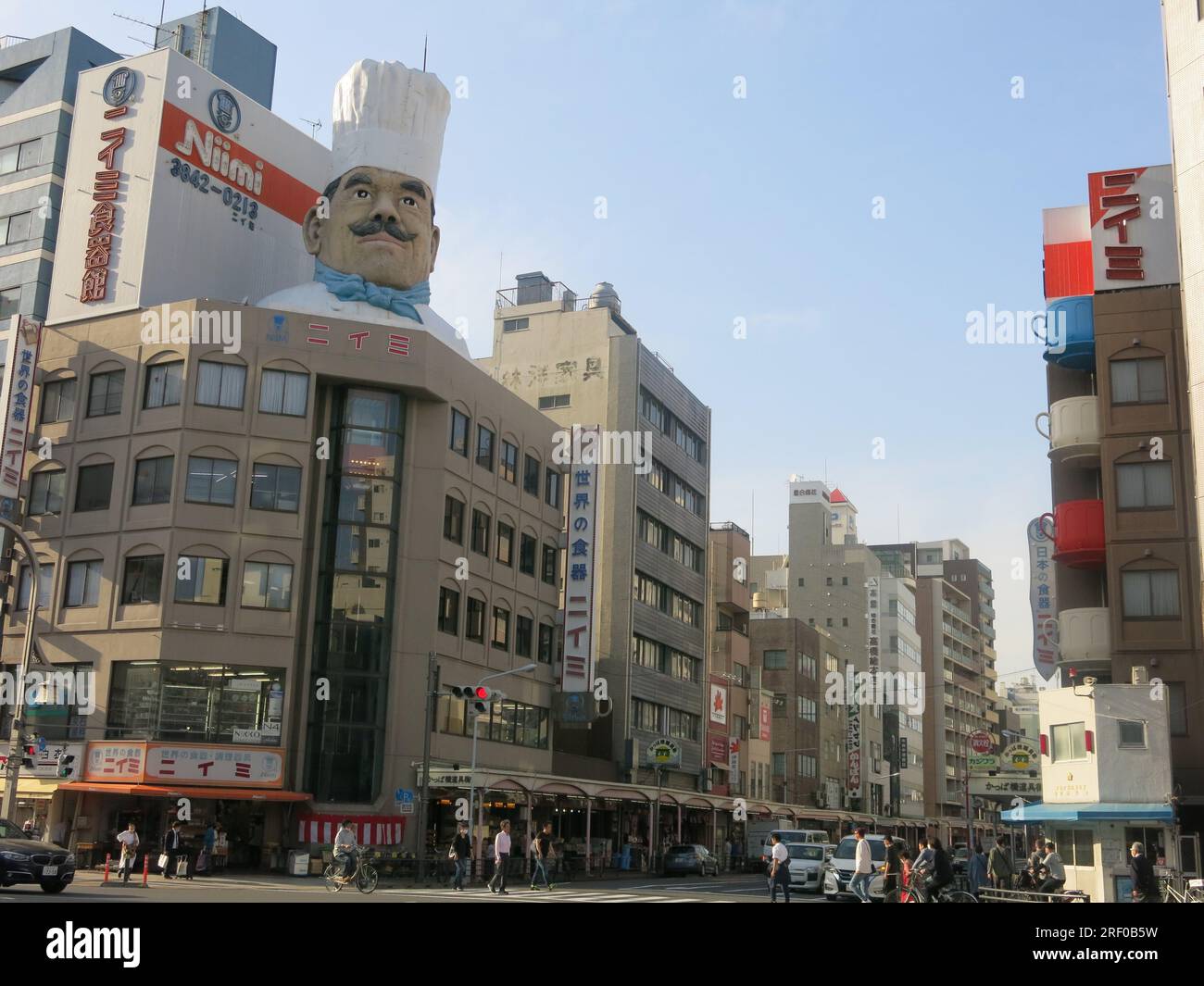 An off-beat tourist destination, view of the southern end of Kappabashi-dori with a model chef & giant teacups signifying 'Kitchen Street'. Stock Photo