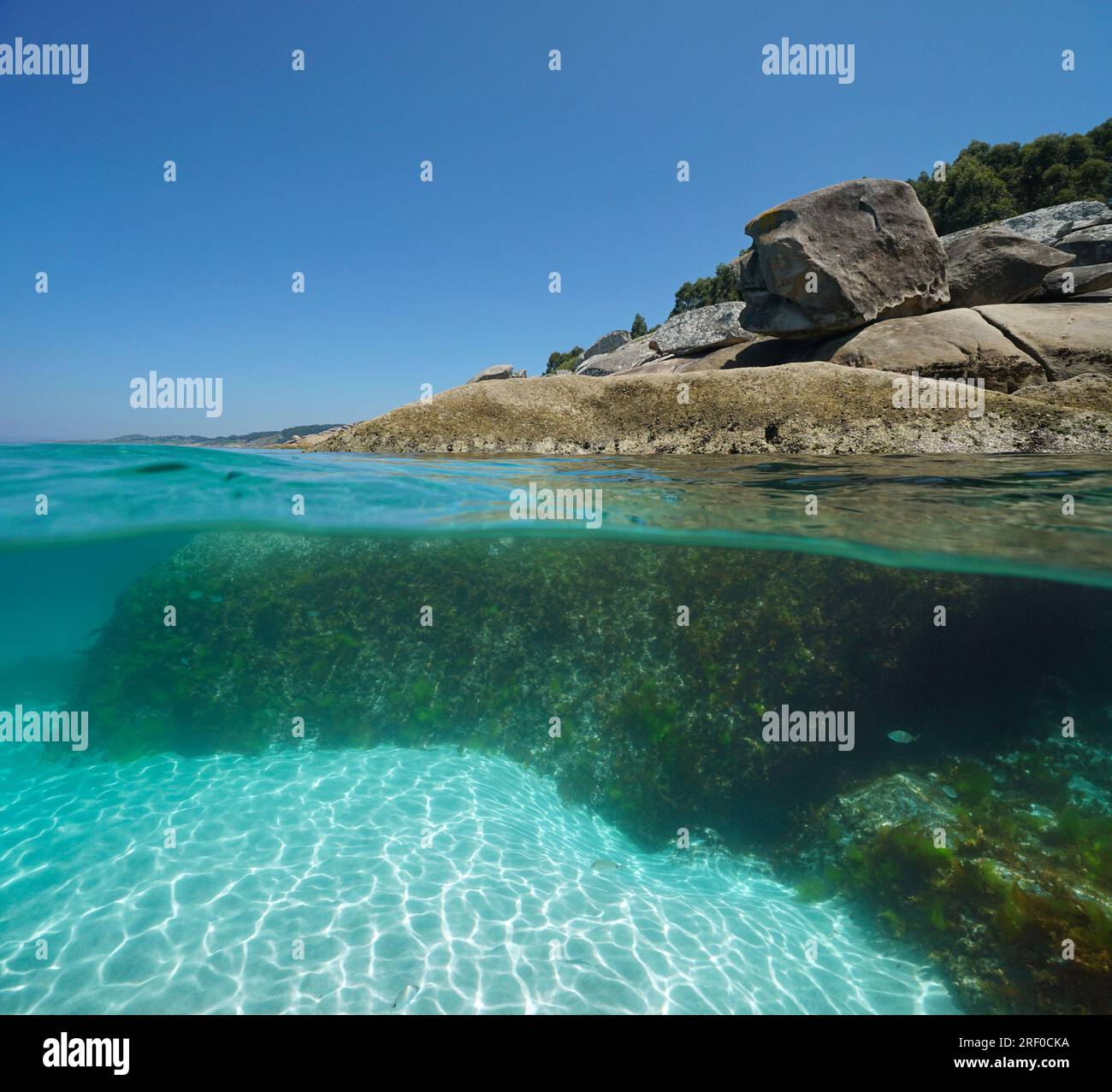Boulders on the sea shore, split view over and under water surface, Atlantic coast in Spain, natural scene, Galicia, Rias Baixas Stock Photo