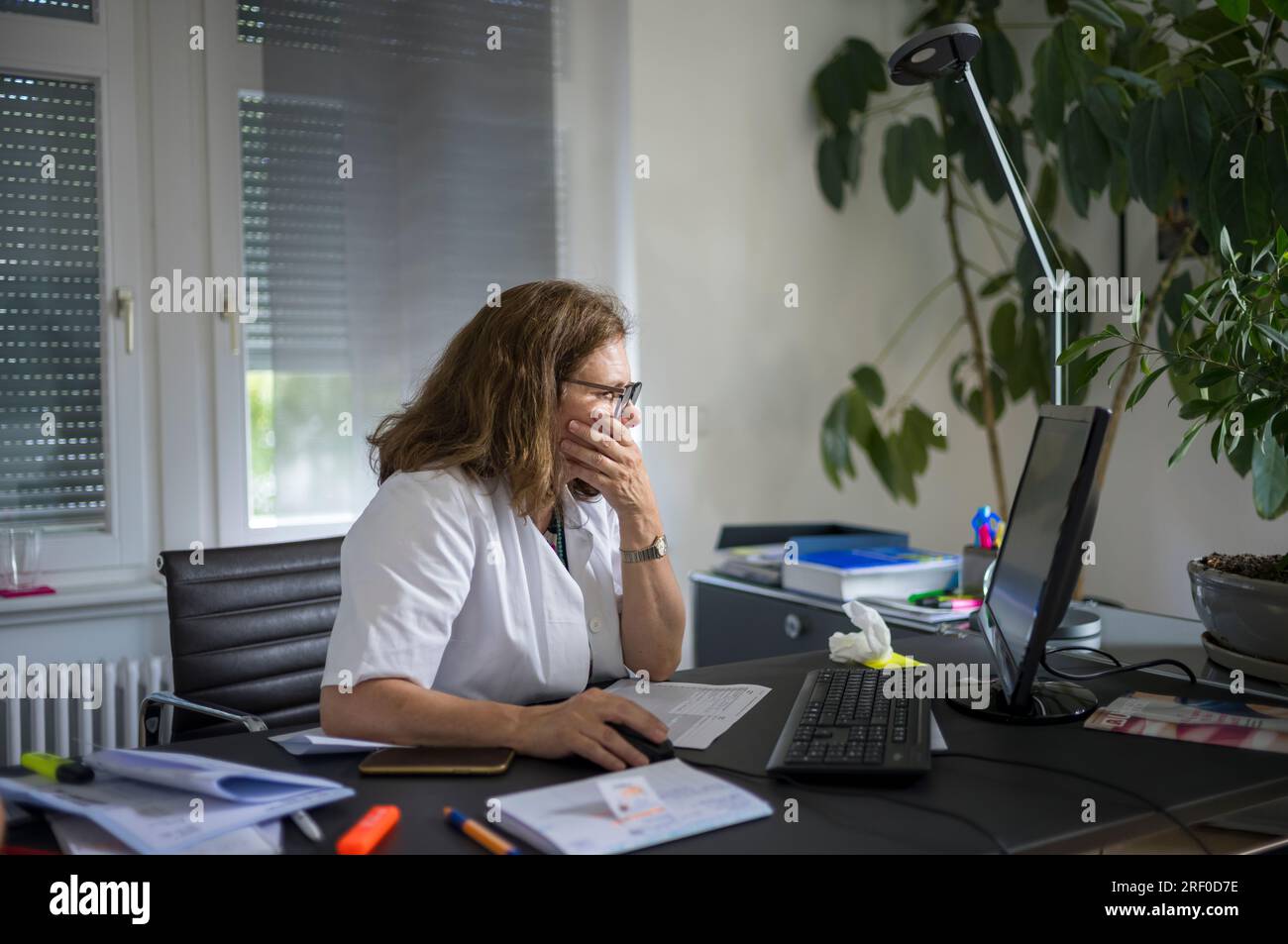 Female doctor at her desk,working on computer Stock Photo