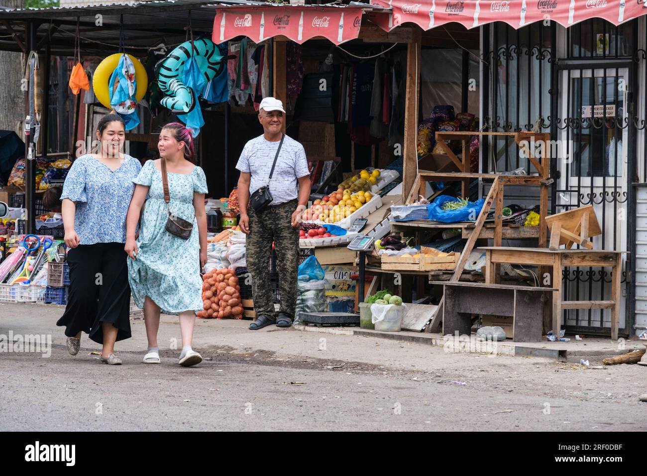 Kazakhstan, Bayseit. Young Women Walking in the Market. Stock Photo