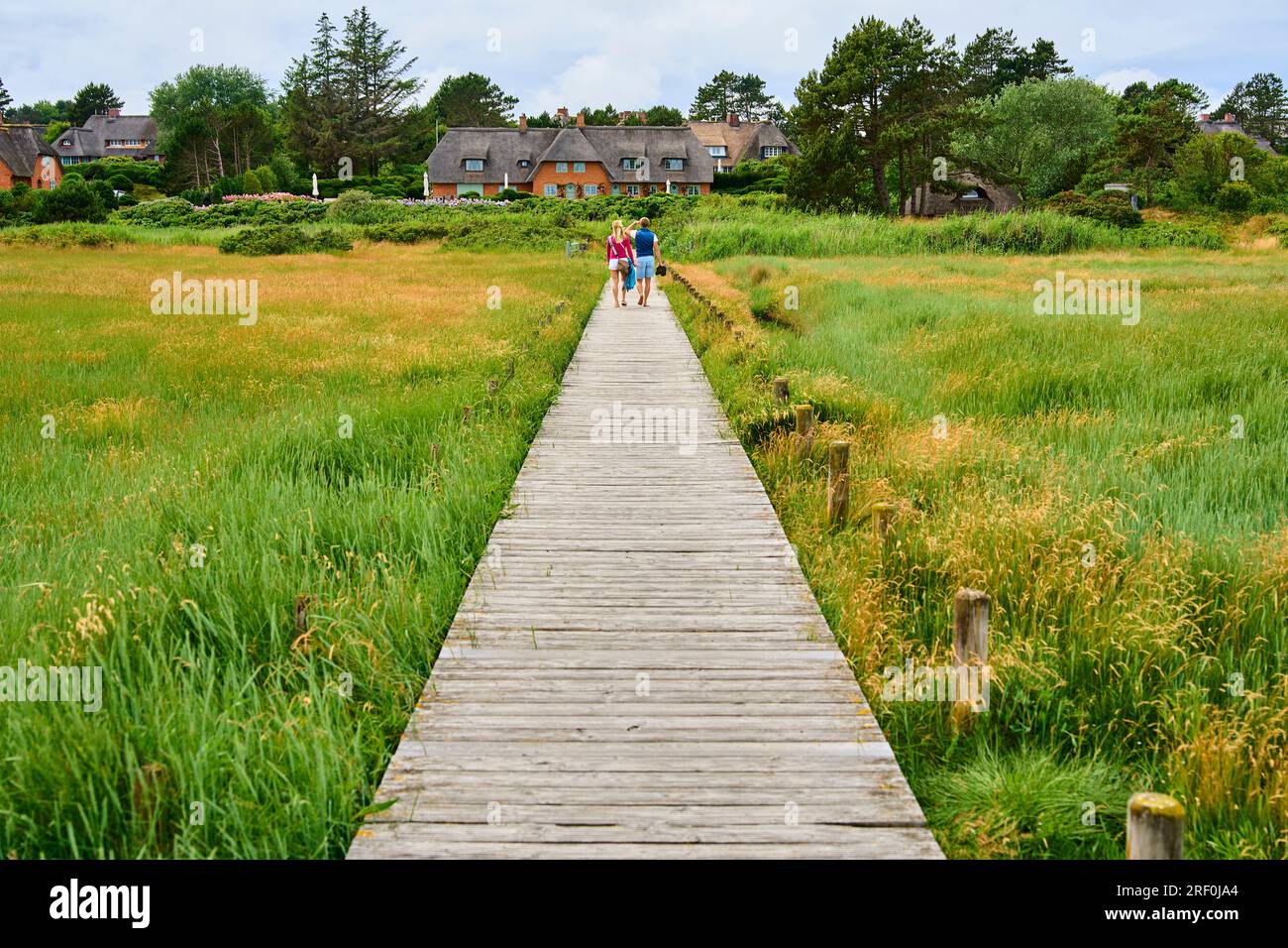 Thatched house at the watt beach with jetty  on June 28, 2023  in Kampen, Sylt Island, Germany.  © Peter Schatz / Alamy Stock Photos Stock Photo