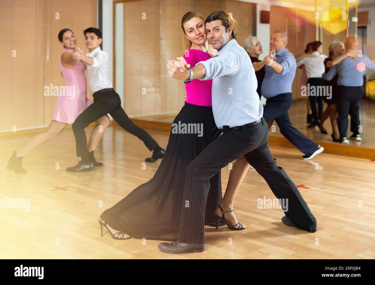 Middleaged pair practicing ballroom dance in dance studio Stock Photo