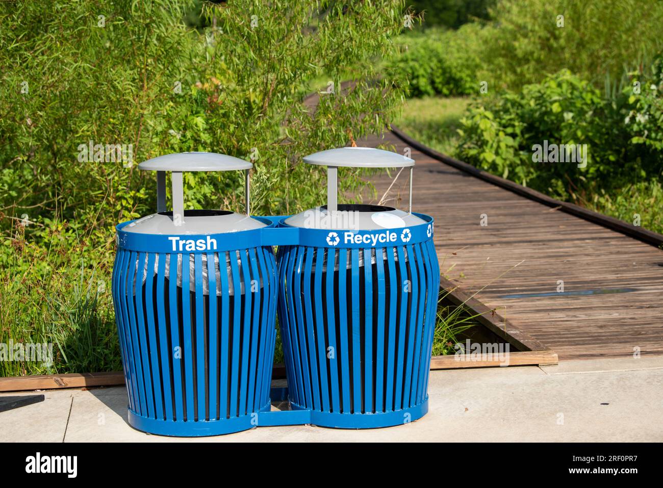 Big blue trash and recycling bins in Osage Park in Bentonville