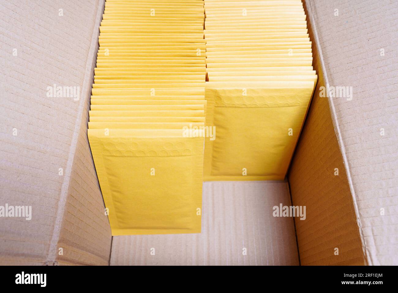 Cardboard box filled with yellow bubble mailers and some free space