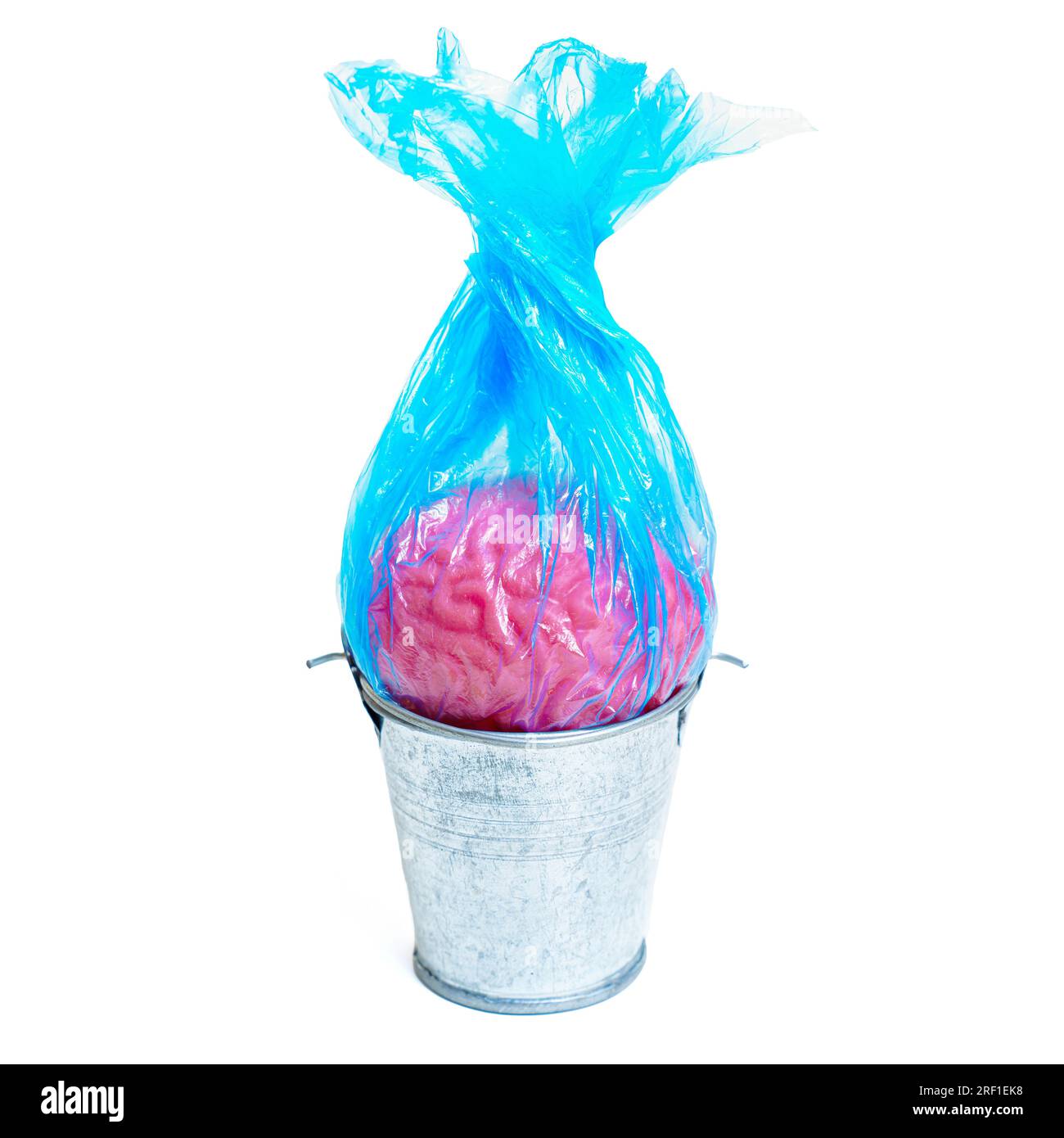 Close-up of a human brain wrapped in a blue trash bag and placed inside a waste bin isolated on white background. Creative mind decluttering concept. Stock Photo