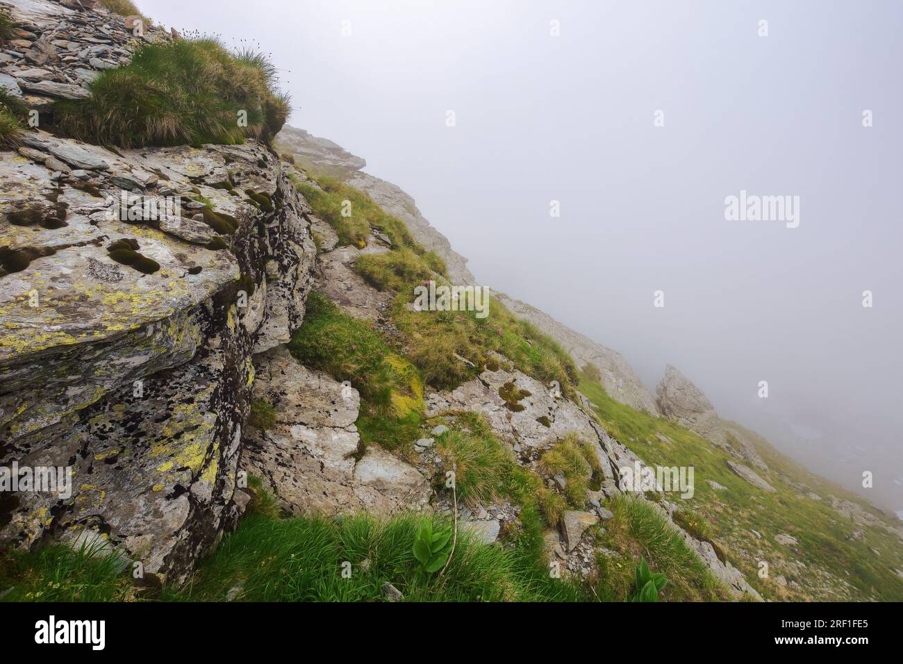 danger and beauty if romanian carpathians. rocky steep slopes in mist
