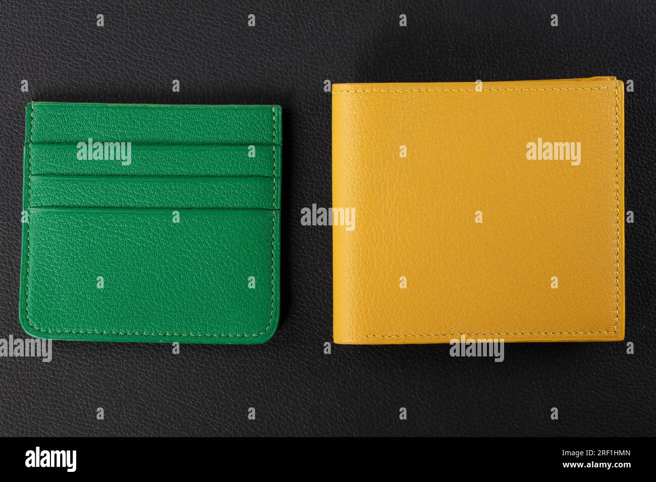 Leather products. Wallet business card holder made of green and yellow genuine leather on a black background. Stock Photo