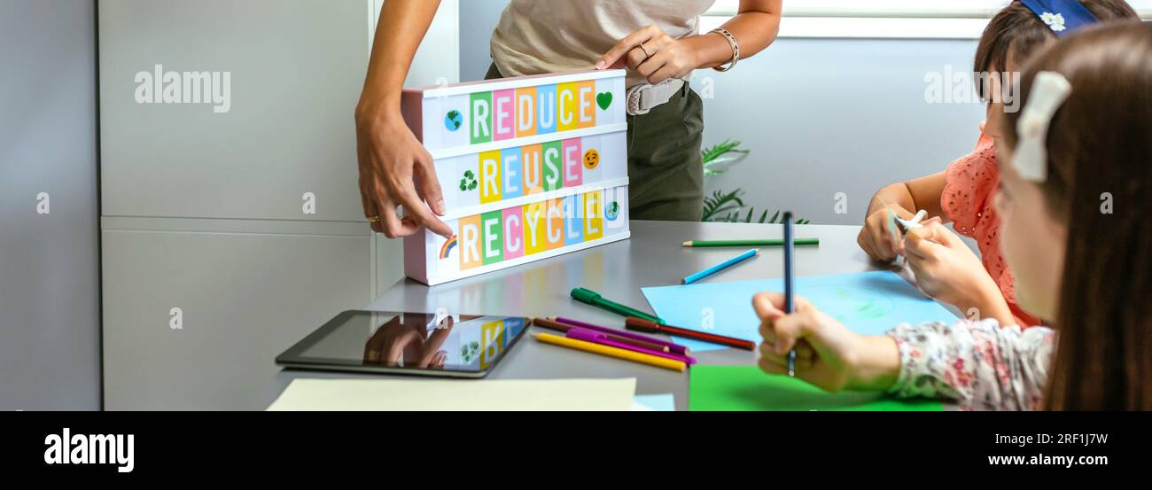 Teacher explaining to students a ecologic process using lightbox with ...