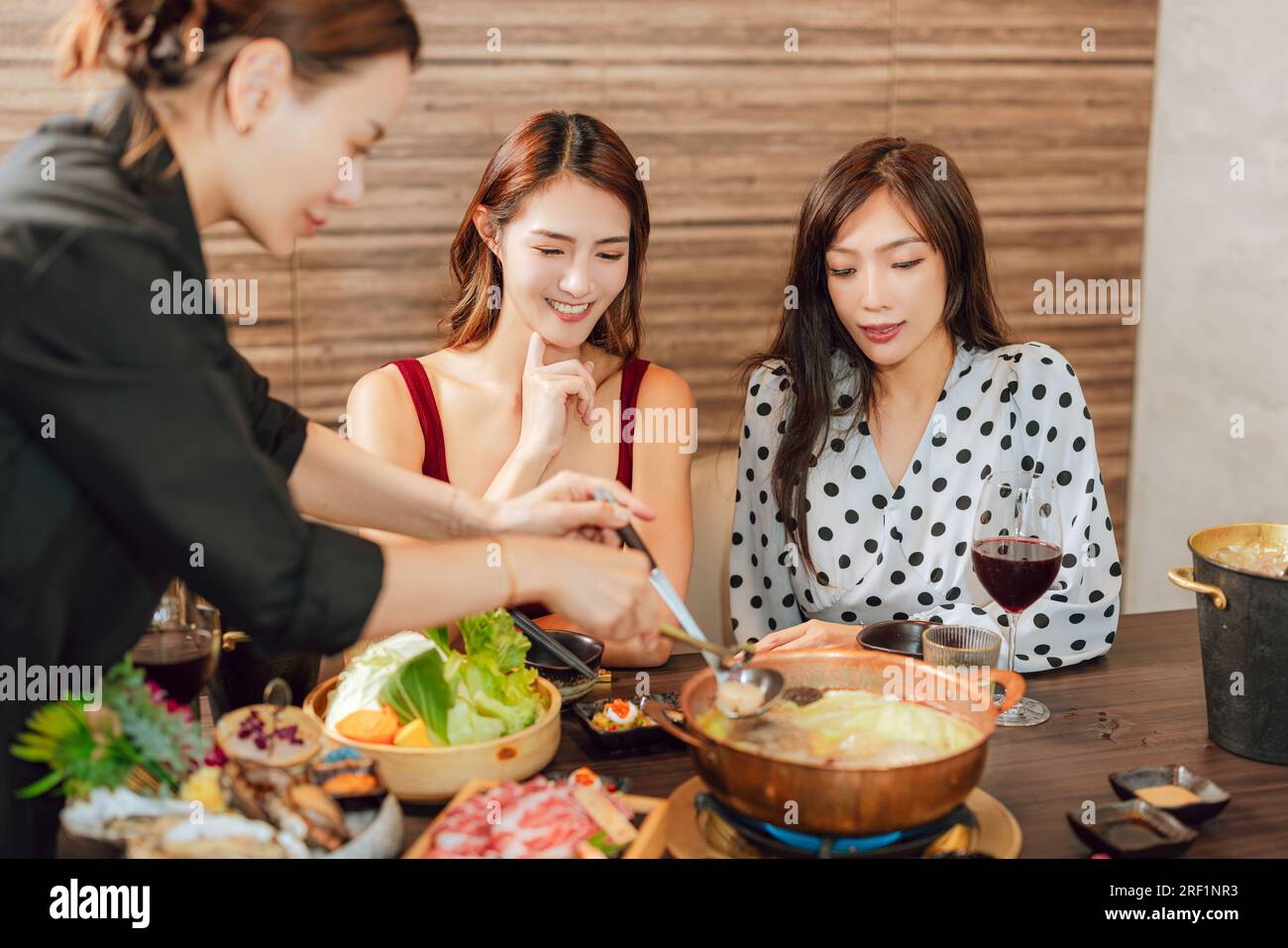 Happy woman dining in hotpots restaurant Stock Photo