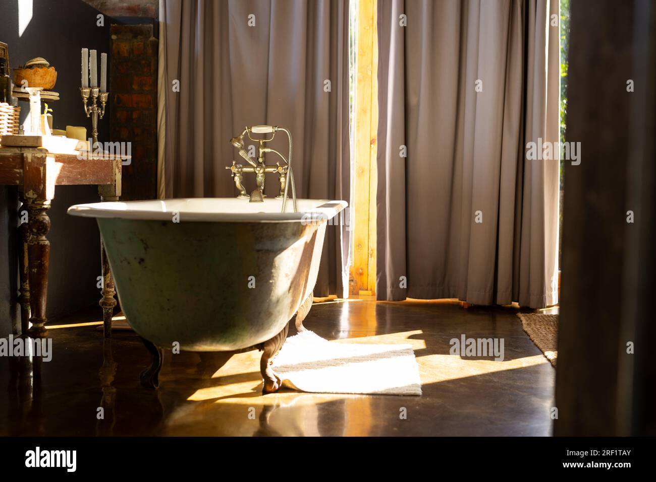Vintage freestanding bathtub in sunny bathroom at home Stock Photo