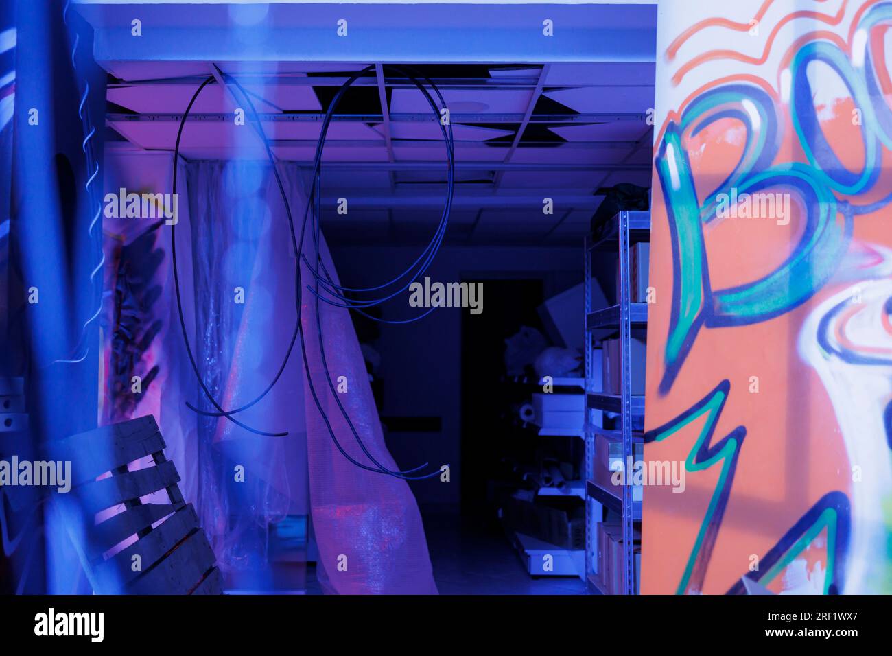 Damaged messy place glowing with neon bright lights, crumbling building with garbage and