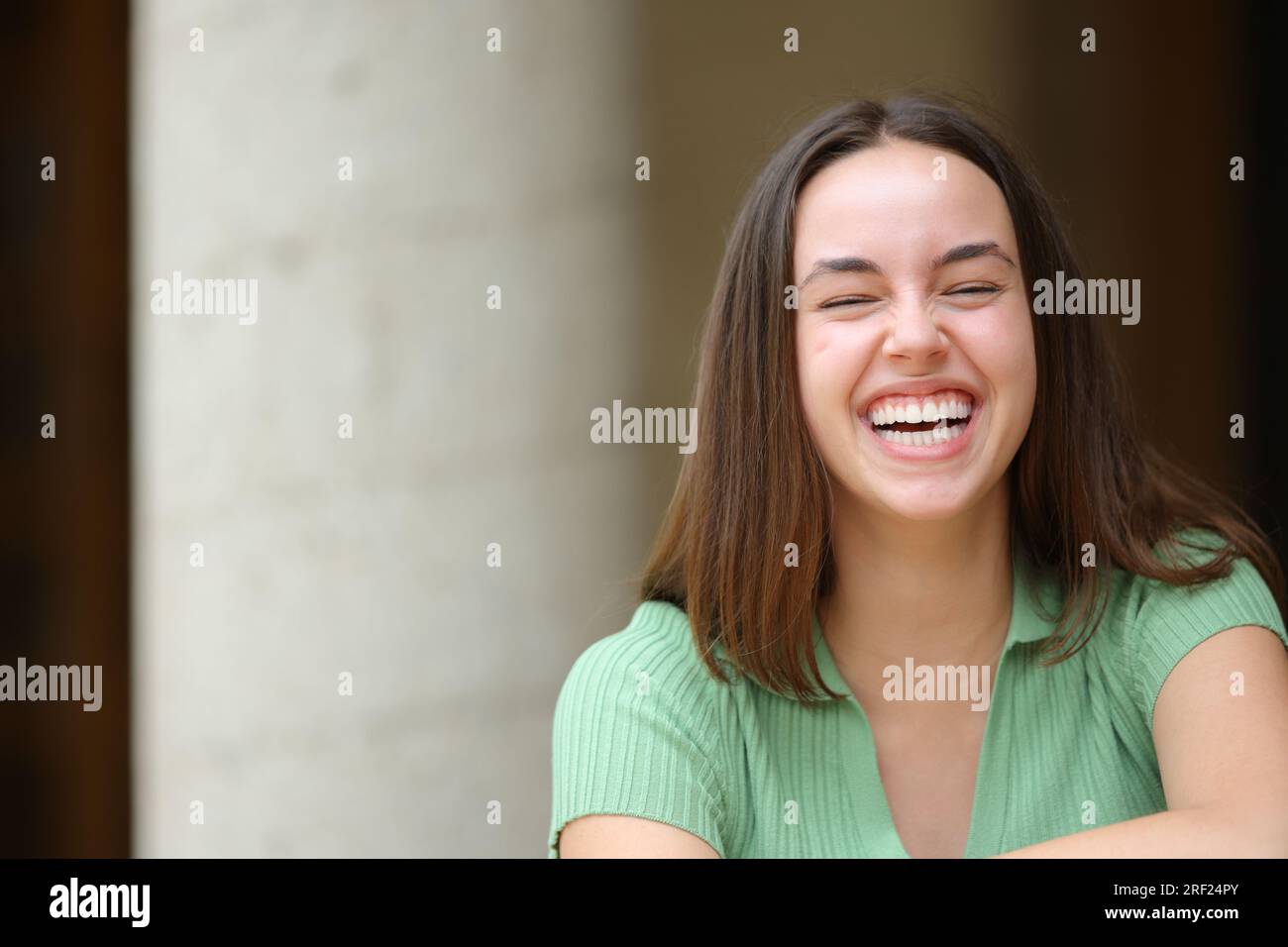 Front view portrait of a happy single woman laughing loud in the street Stock Photo