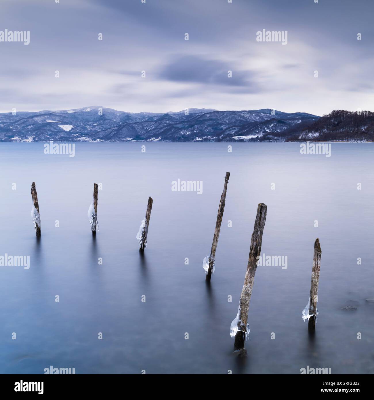 Long exposure shot of wooden sticks in the water at lake Toya, Hokkaido, Japan Stock Photo