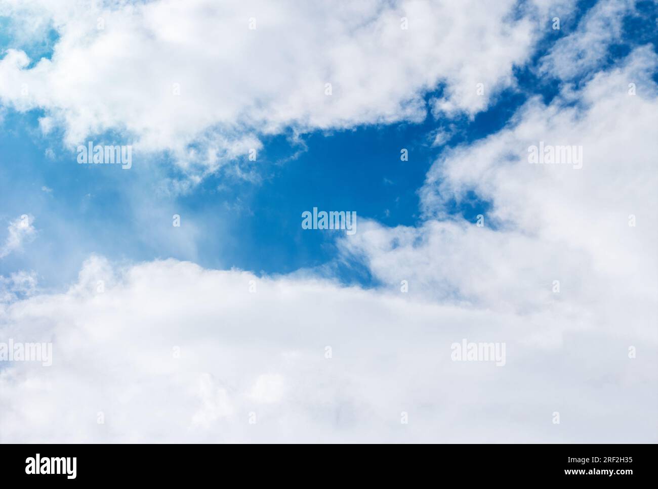 Bright blue sky with sun and white clouds Stock Photo - Alamy
