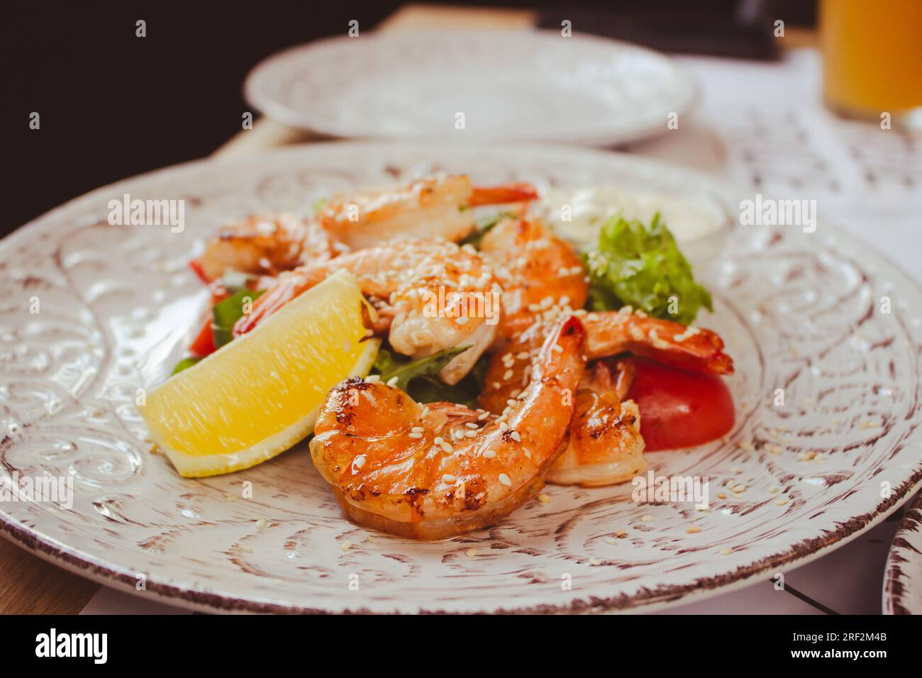 Shrimps with lemon and salad. Seafood close up. Served fish dish. Fish