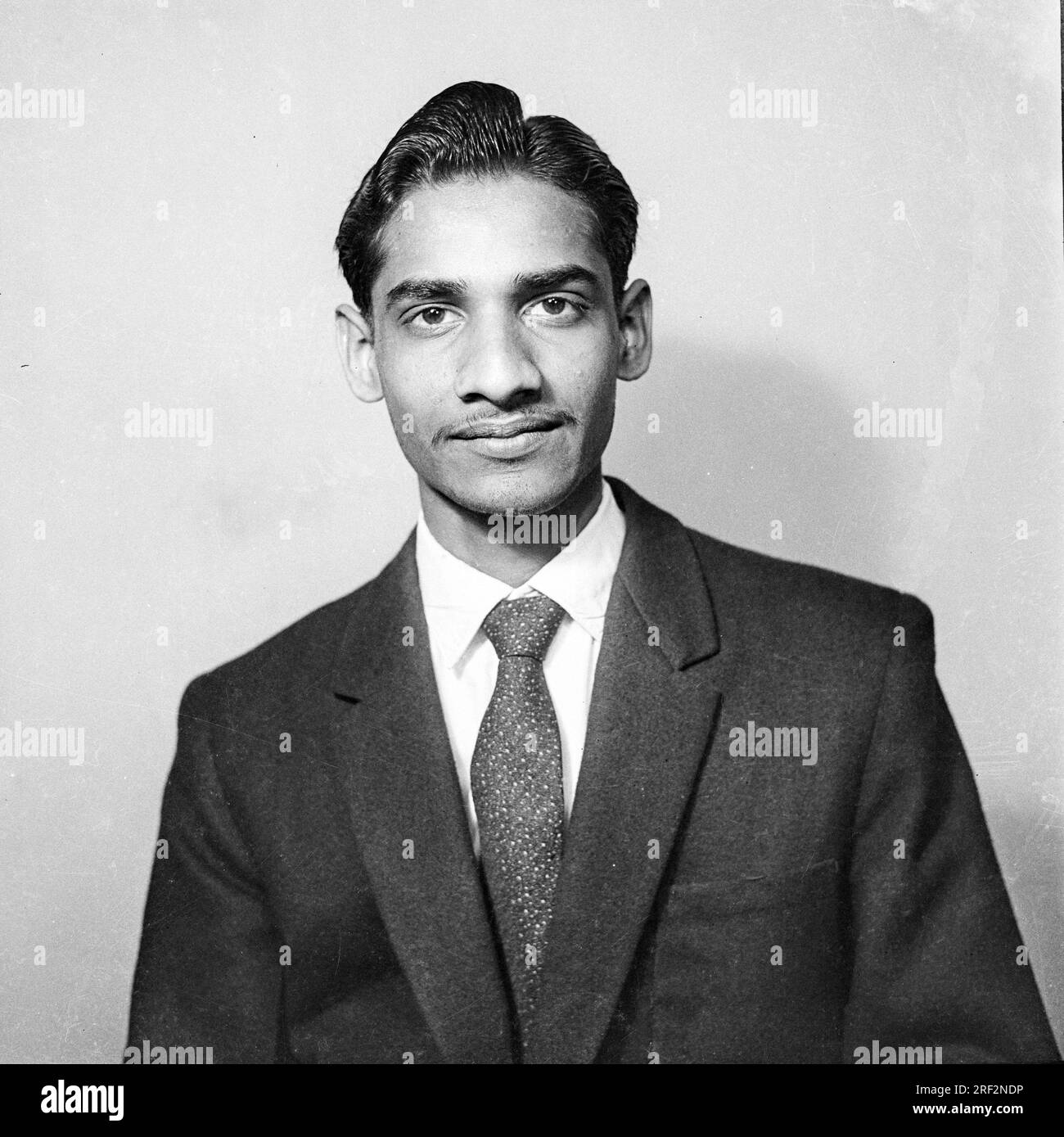 old vintage 1900s black and white picture studio portrait Indian man wearing suit India Stock Photo