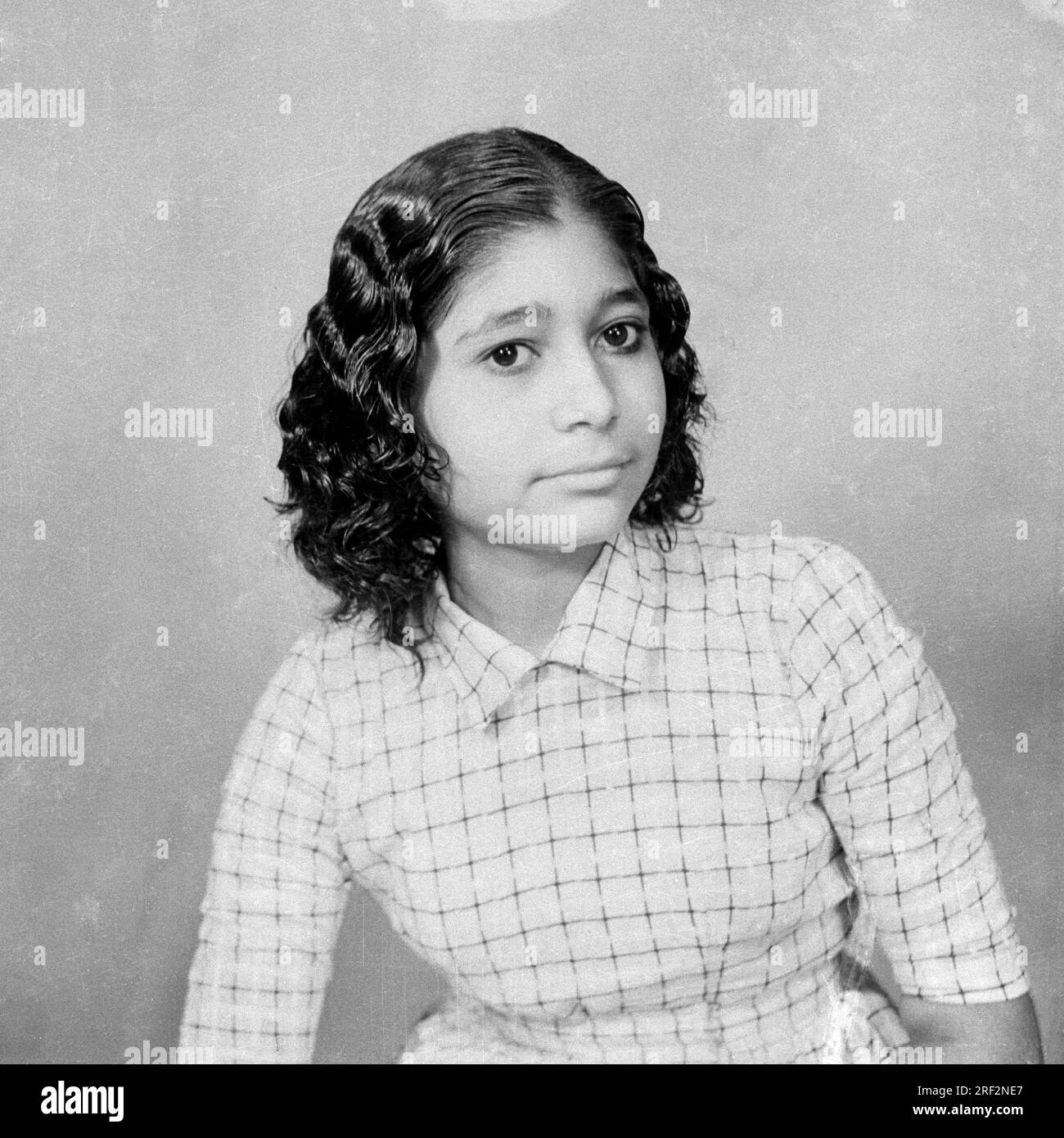 old vintage 1900s black and white studio portrait of Indian girl with short hair India 1940s Stock Photo