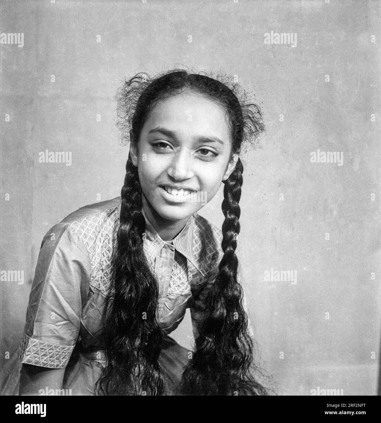 old vintage black and white 1900s picture of Indian girl studio portrait two hair plaits fishtail style India 1940s Stock Photo
