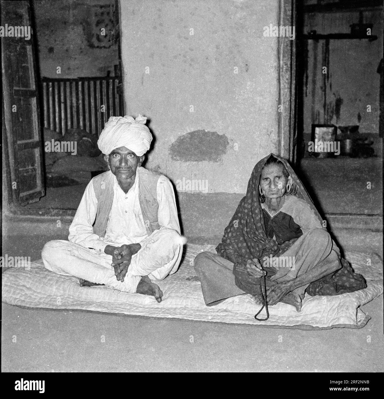 old vintage 1900s black and white picture of Indian couple portrait man woman sitting husband wife wearing sari turban India 1940s Stock Photo