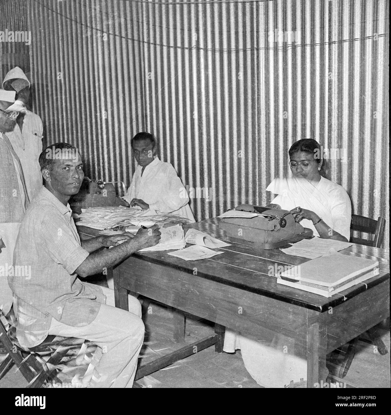 old vintage 1900s black and white picture of Indian office clerk working table manual typewriter India 1940s Stock Photo