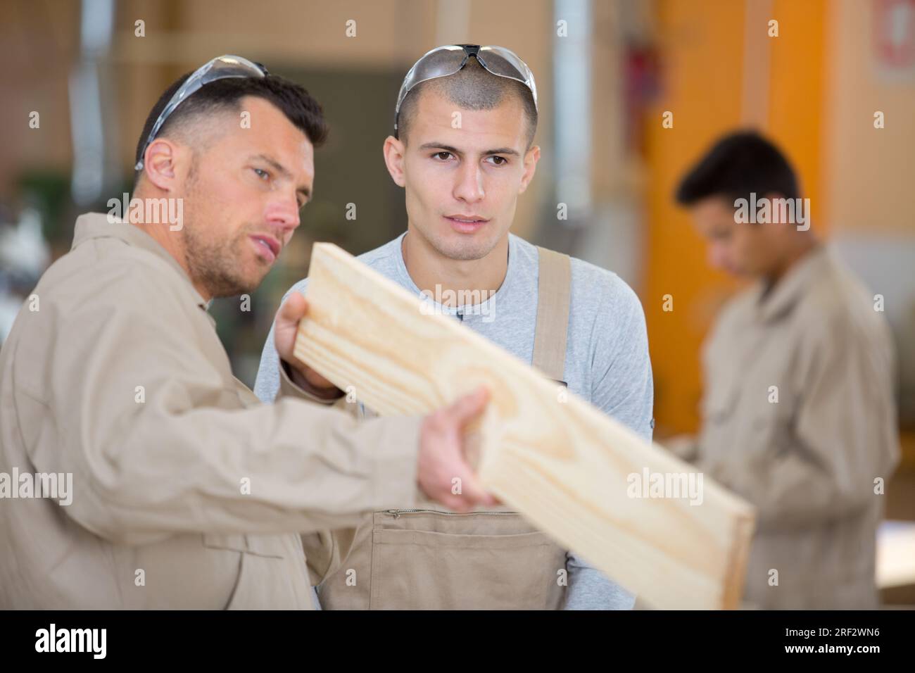 two men working together to build wooden frame Stock Photo - Alamy