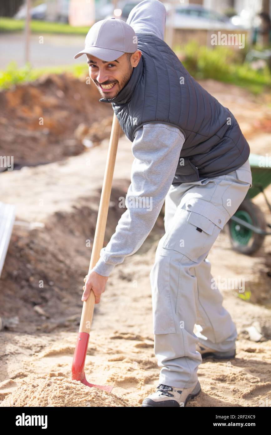 man working hard on construction site holding shovel Stock Photo