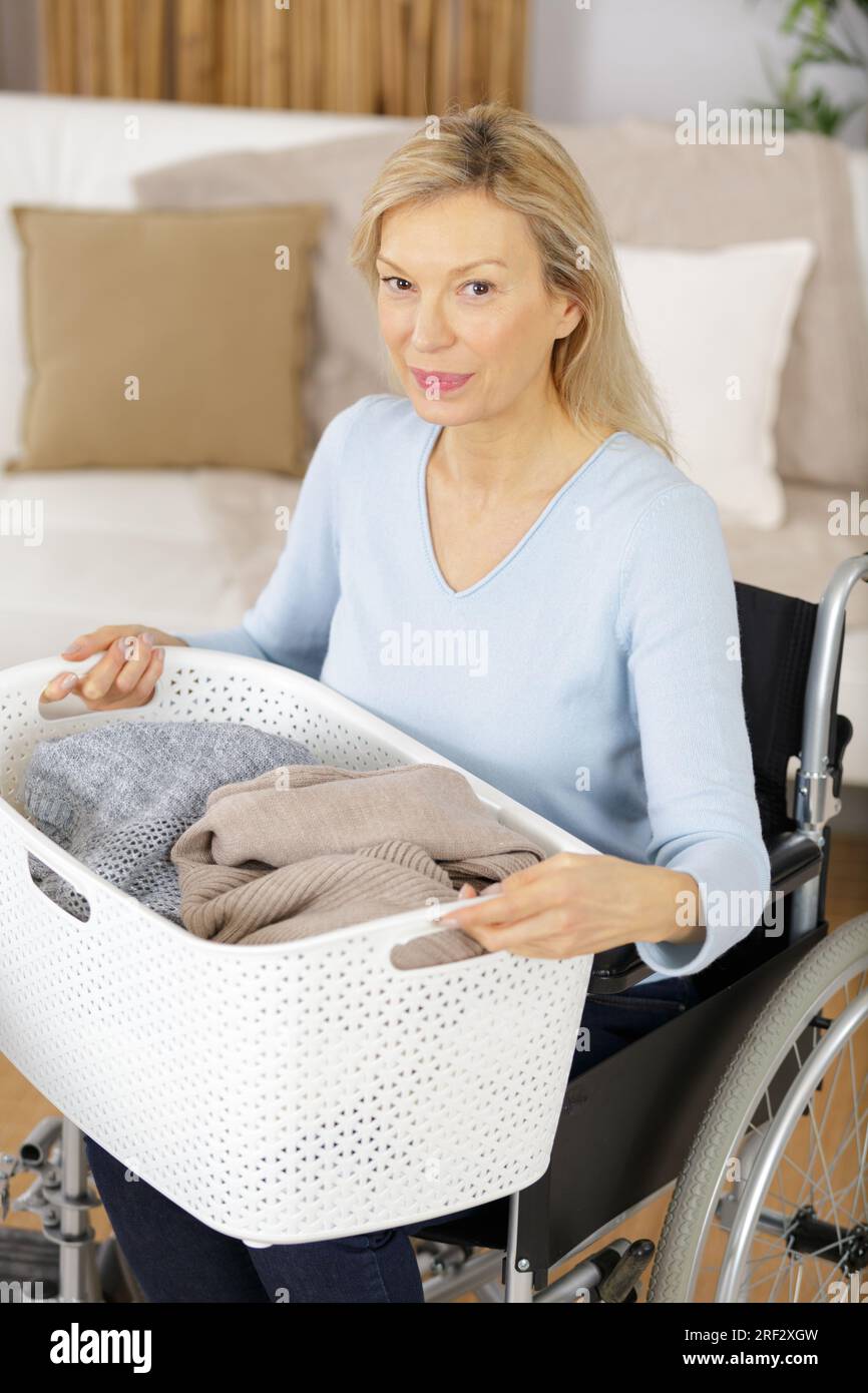 mature woman in wheelchair with a laundry basket Stock Photo Alamy