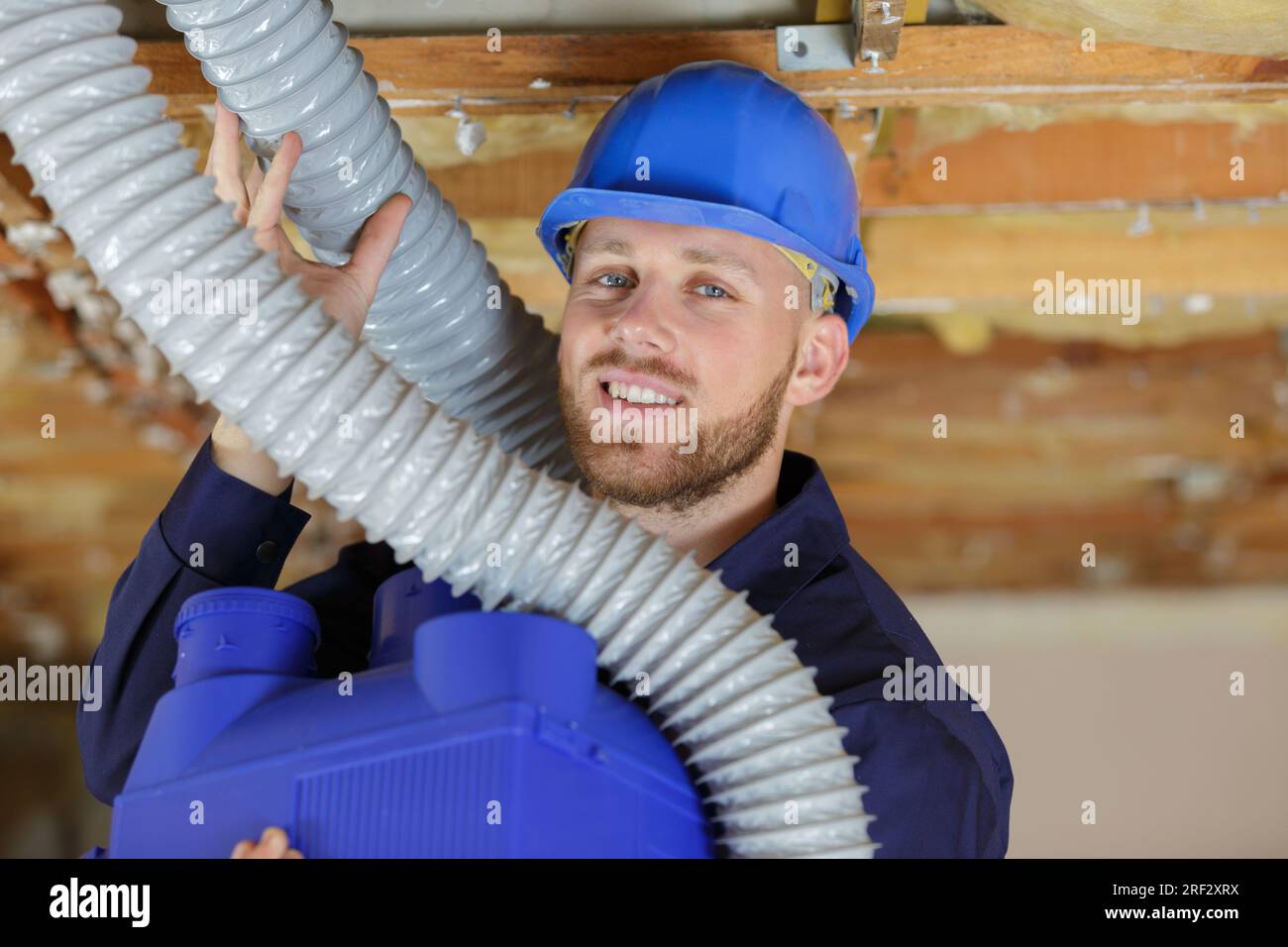 a plumber checking ceiling pipes Stock Photo