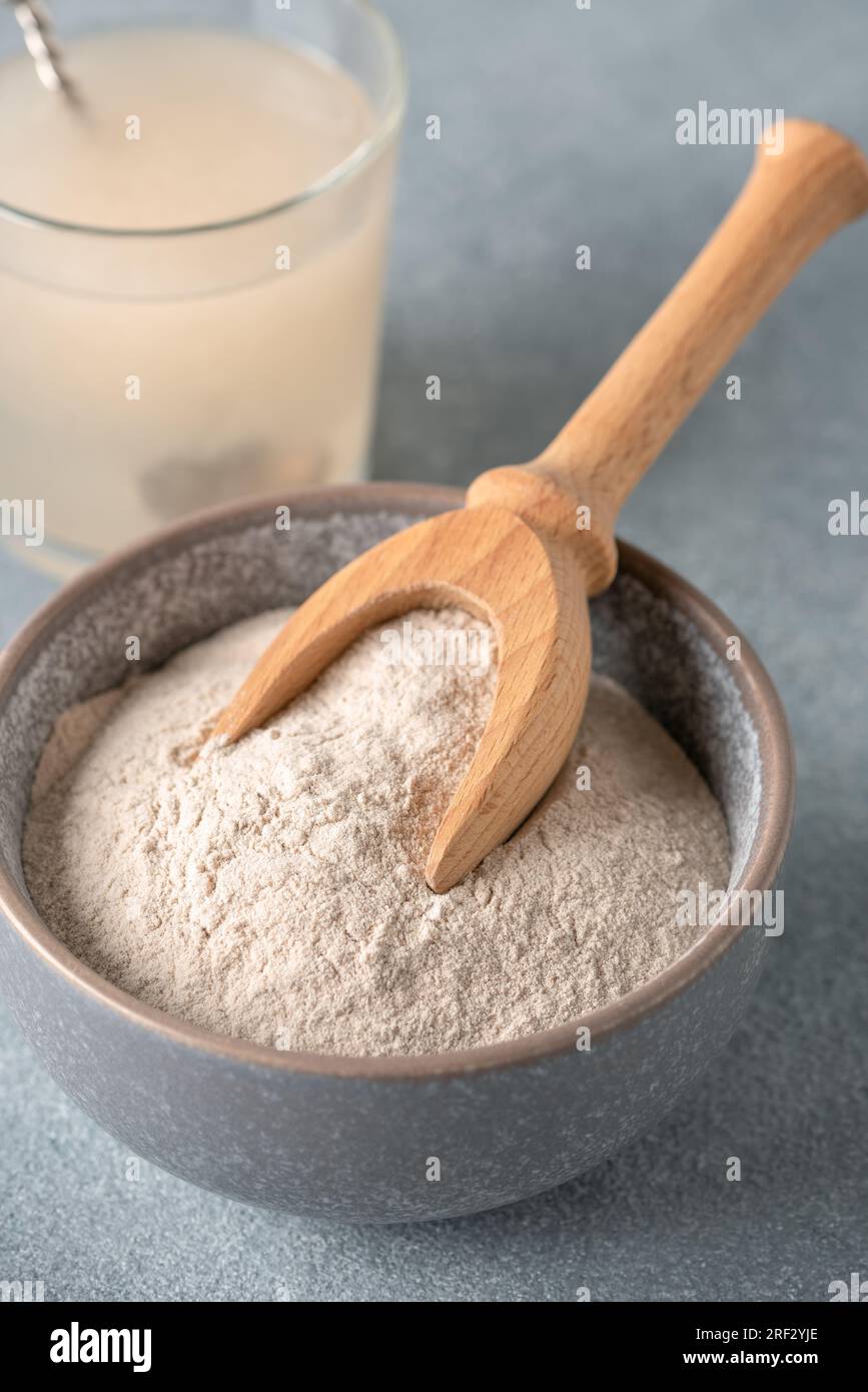 Psyllium husk powder in bowl closeup and glass with of water soluble