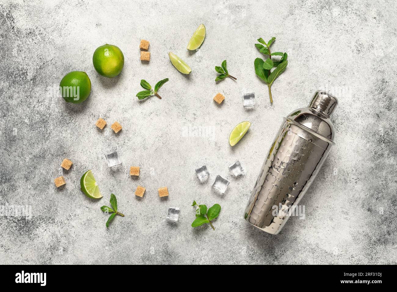 Ingredients for mojito frame, lime, mint leaves, shaker and cane sugar. Light gray vintage background. Top view, flat lay, copy space Stock Photo