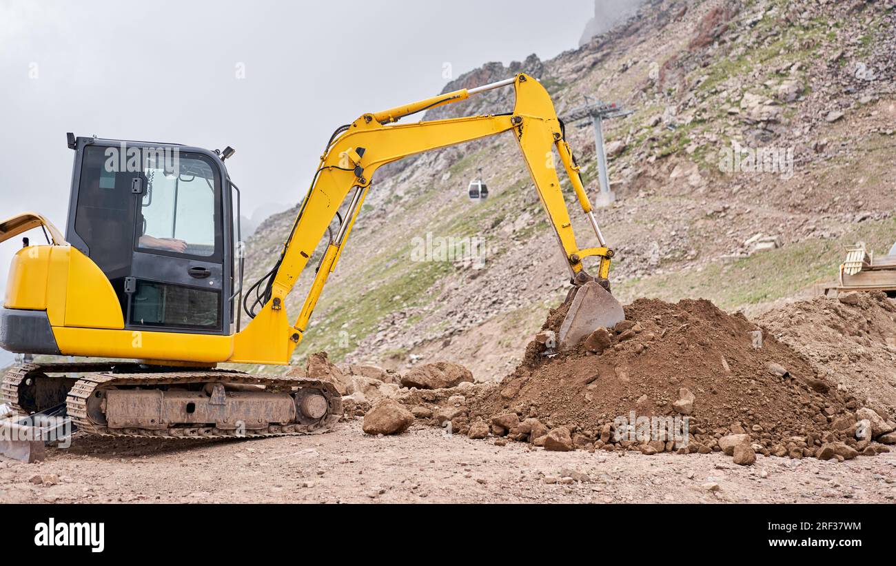 Excavator works in the highlands. Makes a trench for communications ...