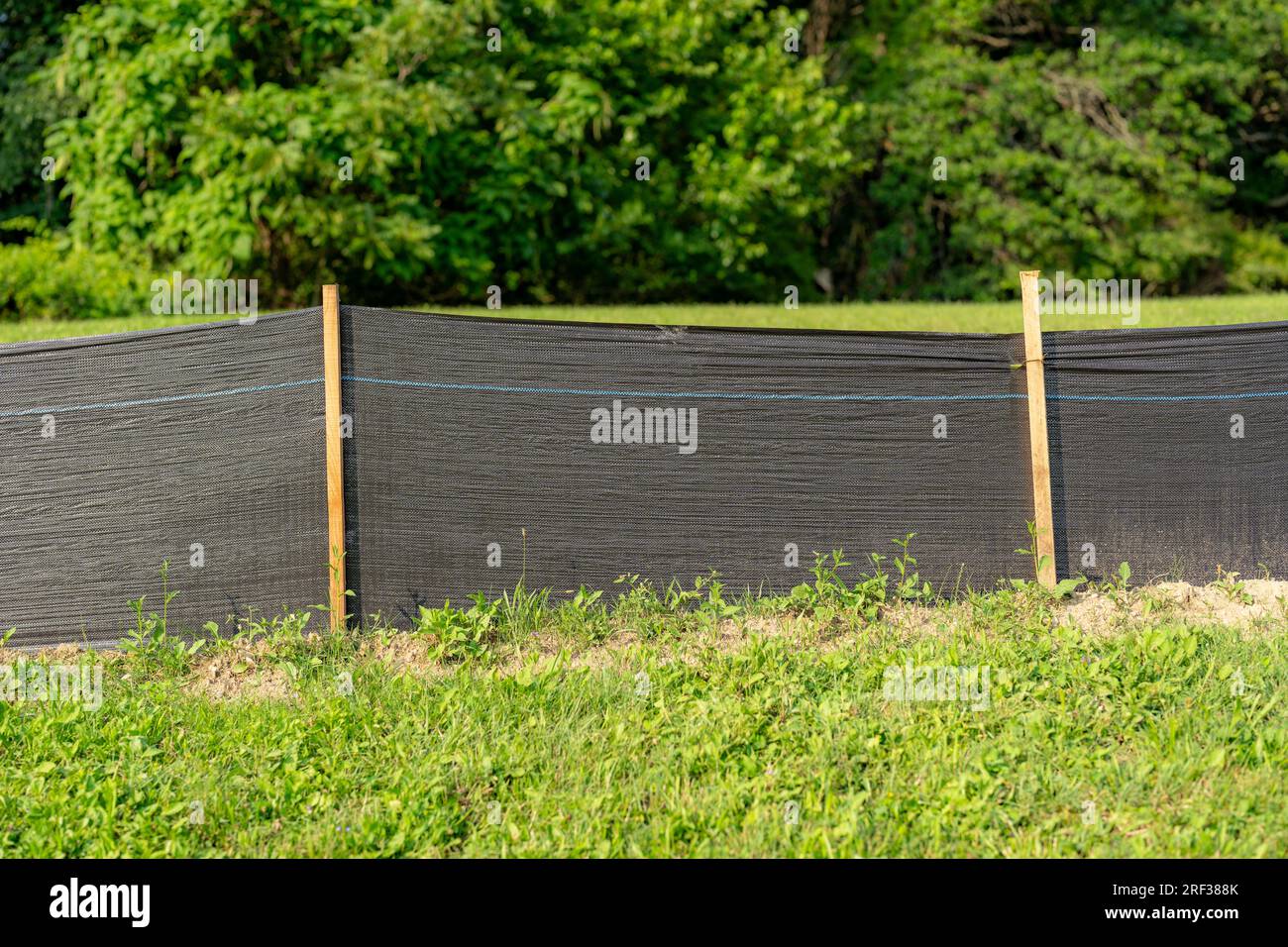Silt Fence fabric with wooden posts installed prior to the start of construction. Stock Photo