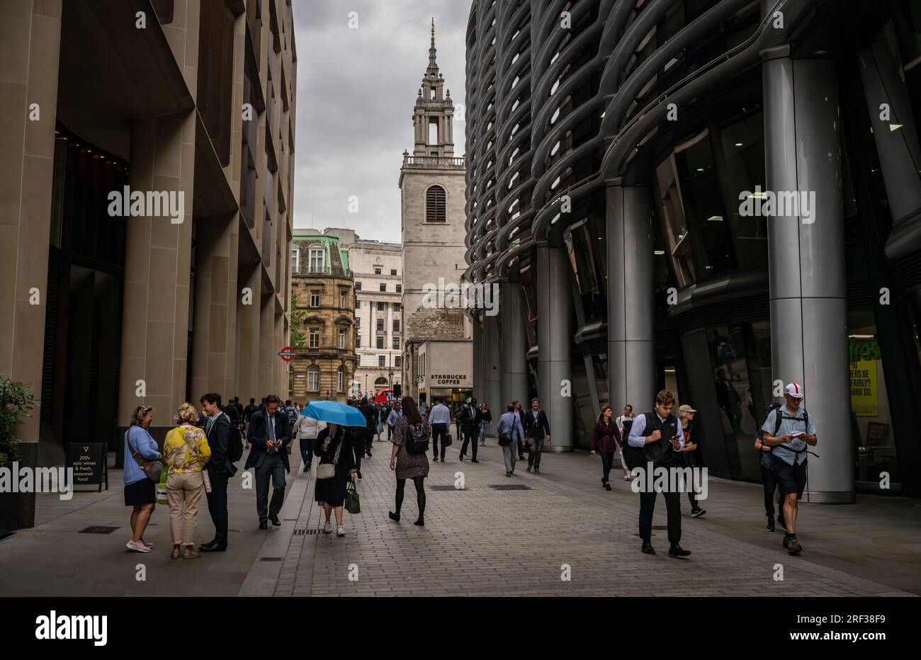 London, UK: People walking along Walbrook in the City of London. The Church of St Stephen Walbrook is at the end of the road. Stock Photo