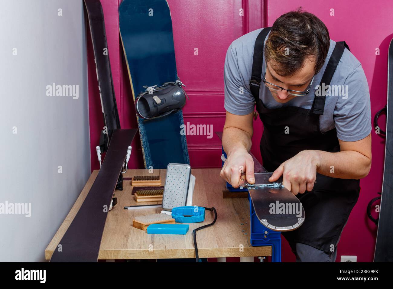 Careful wax removal from ski base with plastic scraper Stock Photo Alamy