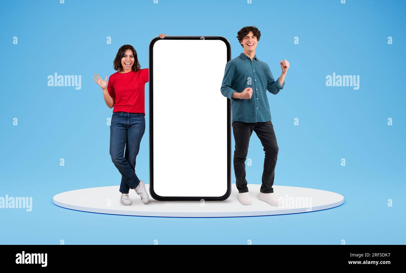 Excited arab woman and european woman standing by big phone Stock Photo