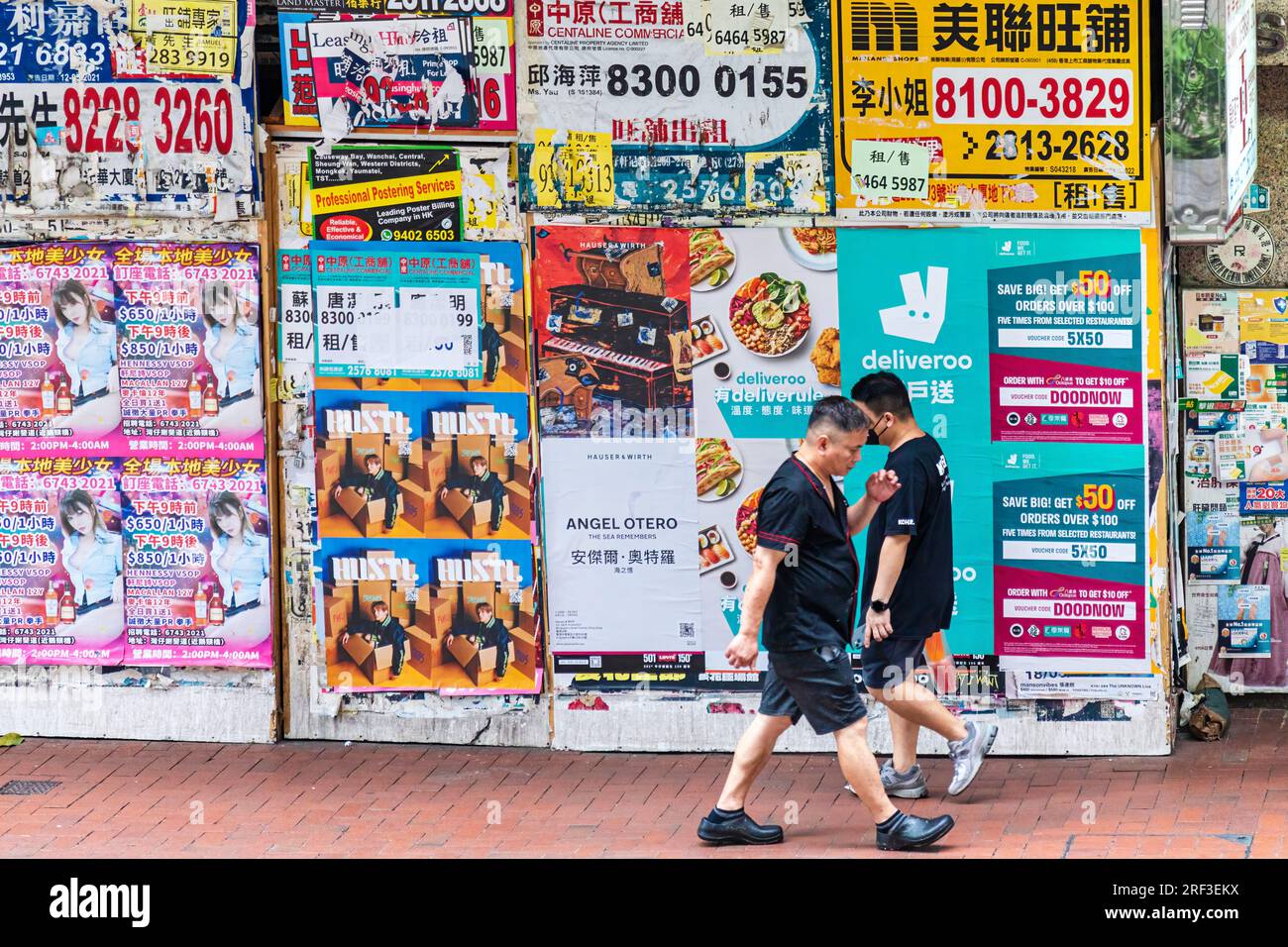 People walking past real estate and advertising posters on city centre