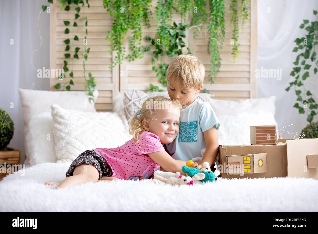 Cute sweet toddler children, tickling feet on the bed, laughing and smiling, childish mischief, happiness and joy Stock Photo